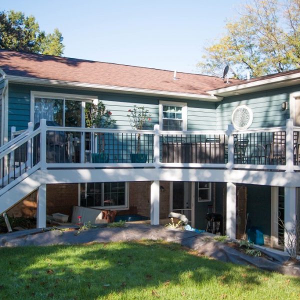 Second story deck with white vinyl railings and black spokes