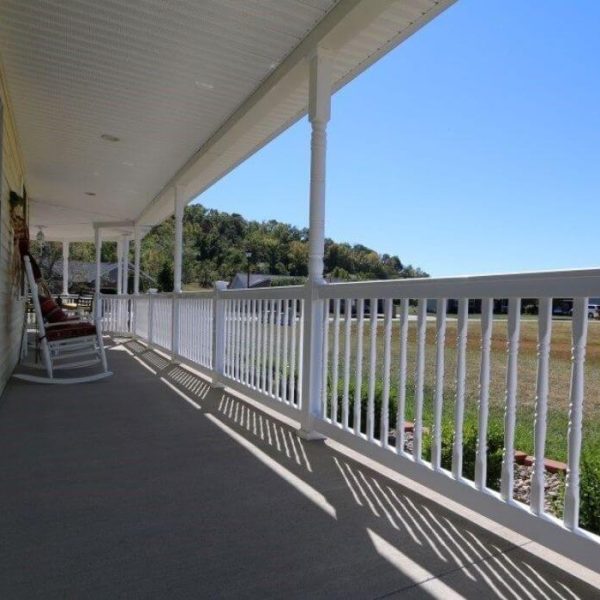 Covered concrete patio with white vinyl railings