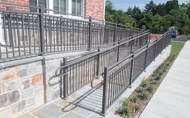 Gray aluminum railings up a handicap accessible ramp