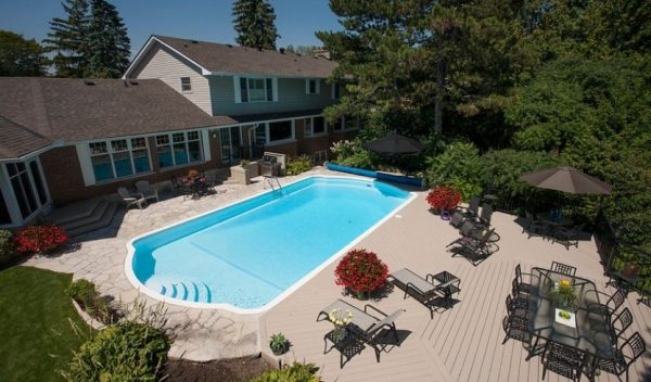 Backyard pool with tan vinyl deck and patio